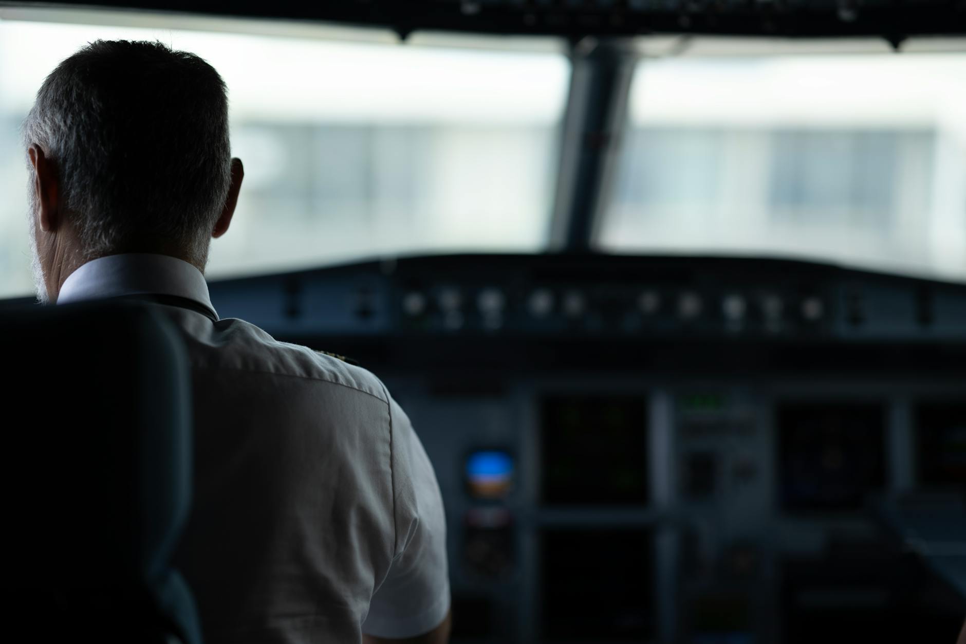Pilot linii lotniczej w kokpicie podczas kontroli systemów samolotu