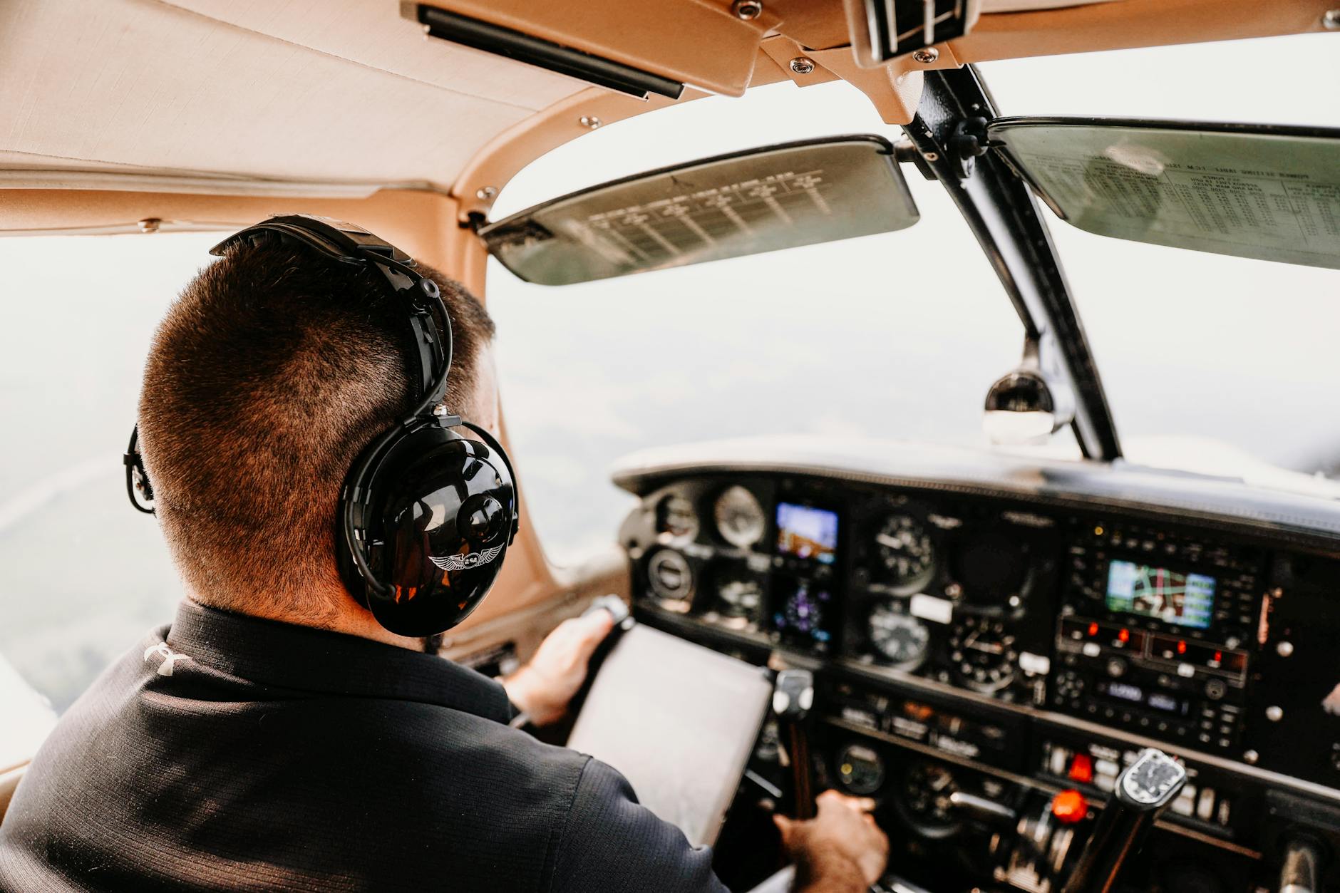 Pilot w kokpicie samolotu pasażerskiego obserwuje przyrządy pokładowe