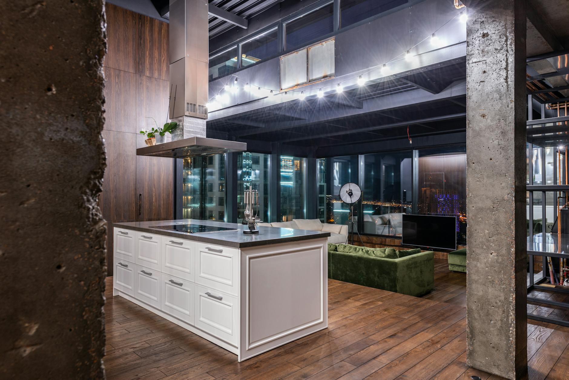 Nowoczesny salon z aneksem kuchennym w loftowym stylu wieczorem Nowoczesny salon z aneksem kuchennym w loftowym stylu wieczorem