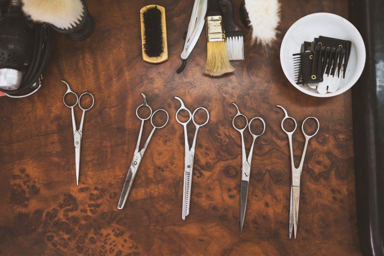 Zestaw vintage’owych nożyczek i szczotek barberskich na drewnianym blacie